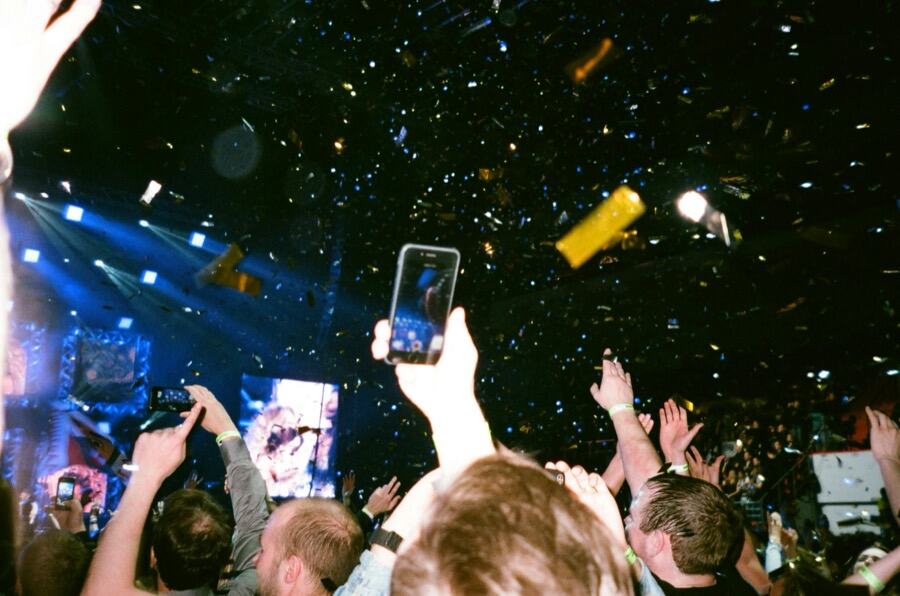 Crowd of guests holding up their phones to film at a live event