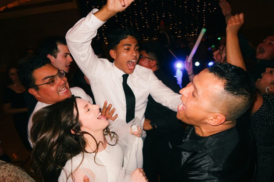 Guests dancing with arms in the air at a wedding party